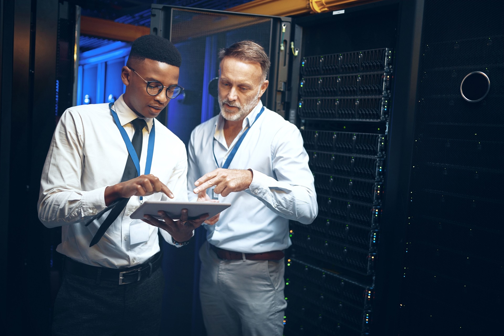 Shot of two technicians using a digital tablet while working in a server room